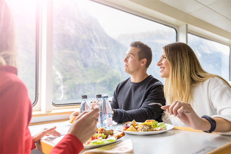 Taking in the views through large windows while eating lunch on Milford Sound Nature Cruise